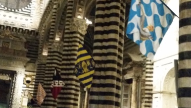The contrade flags displayed inside the Duomo.