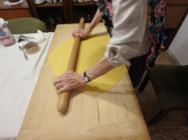 Maria with speed and agility, gets the dough to the width of the board in about five minutes. I'm kind of just standing and watching